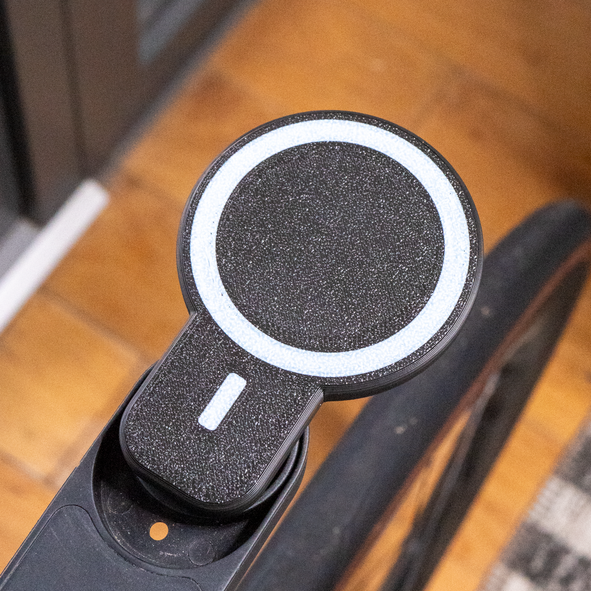 Close-up of a black and white electronic device on a wooden floor.